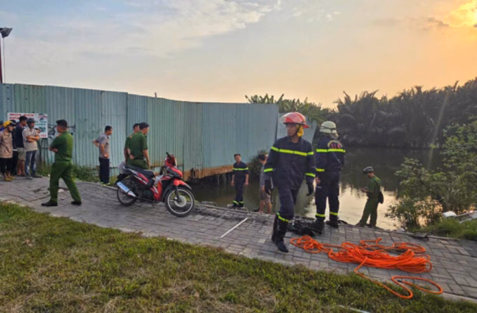 TP HCM: Tài xế xe máy công nghệ bị cuốn vào cống nước tử vong Người dân tập trung theo dõi lực lượng chức năng tìm kiếm nạn nhân, tối 24/7. Ảnh: Đình Văn