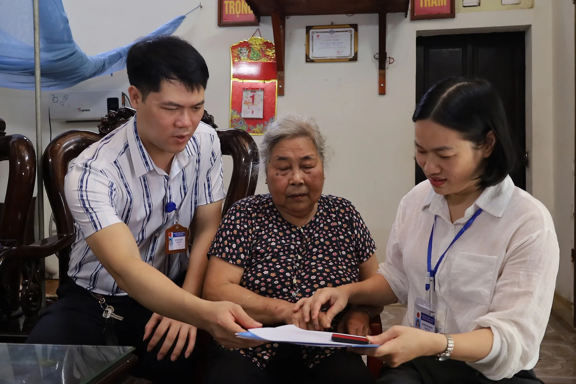 Cụ Đặng Thị Hợp ̣̣̣phấn khởi vì được cán bộ đến tận nhà hỗ trợ giải quyết thủ tục hành chính. Ảnh: Kim Nhuệ