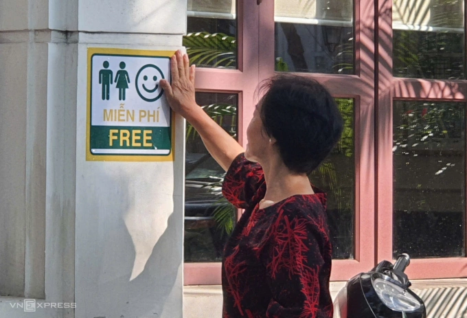 Hà Nội ra quân tổng vệ sinh môi trường trên toàn thành phố Đại diện tổ dân phố đi vận động, dán logo vệ sinh miễn phí tại một cửa hàng trên phố Phan Chu Trinh, phường Cửa Nam, sáng 2/8. Ảnh: