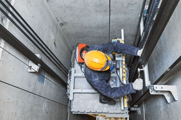 Thợ lắp đặt thang m&aacute;y đang kiểm tra thiết bị