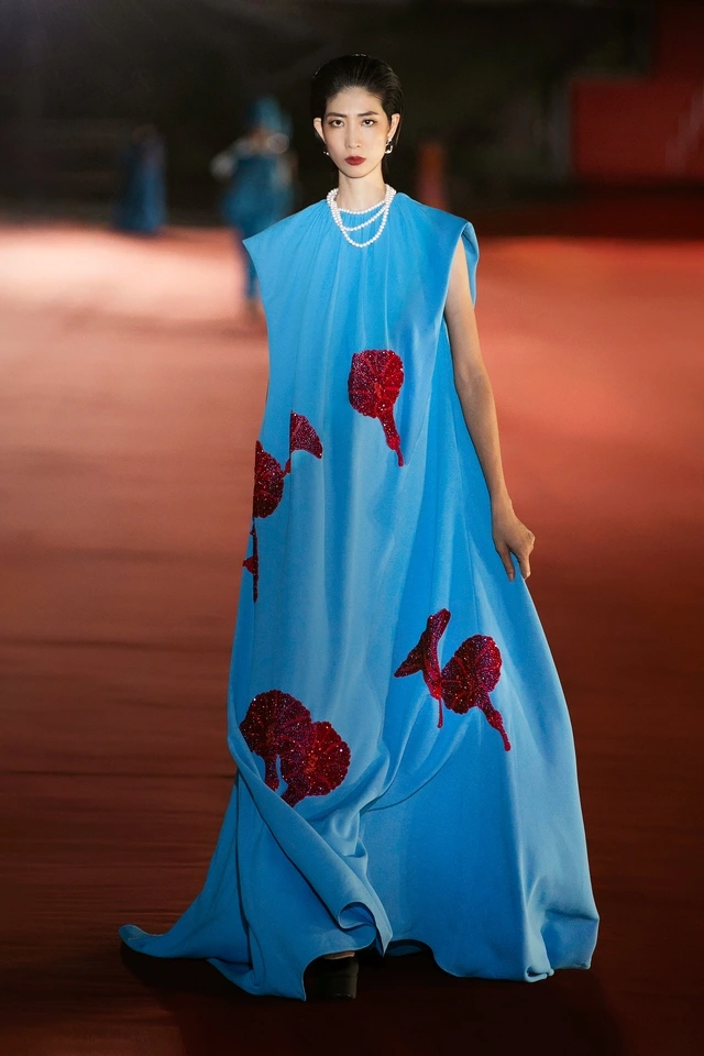 Tiểu Vy làm vedette ở sàn runway bên sông Hàn Điểm nổi bật của BST còn nằm ở kỹ thuật đính kết họa tiết hoa muống biển và pháo hoa được xử lý in và đính nổi 3D bằng chỉ màu, sequin và cườm