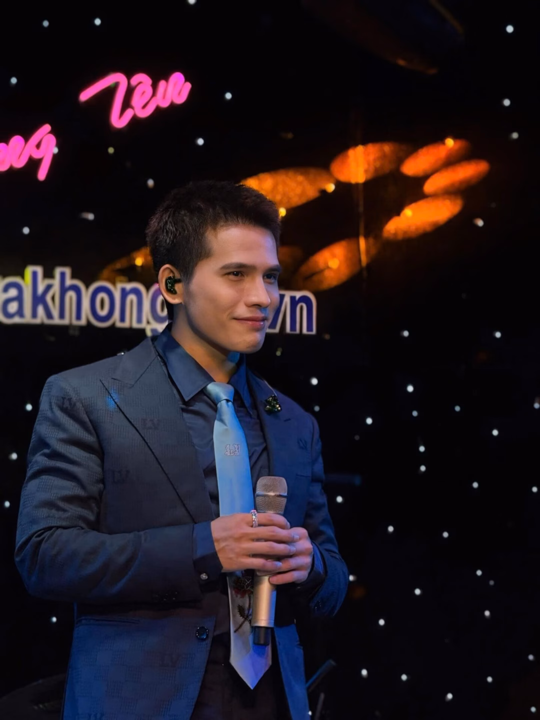 May be an image of 2 people, microphone, dinner jacket, concert and text that says 'La Không ngtrakhon'