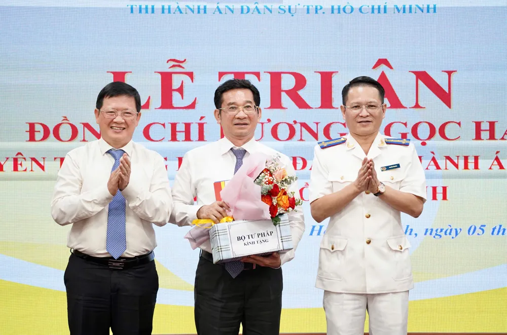 Ông Dương Ngọc Hải (giữa) nhận hoa và quà tri ân của Bộ Tư pháp và Thi hành án dân sự TP.HCM Ông Dương Ngọc Hải nhận hoa và quà tri ân