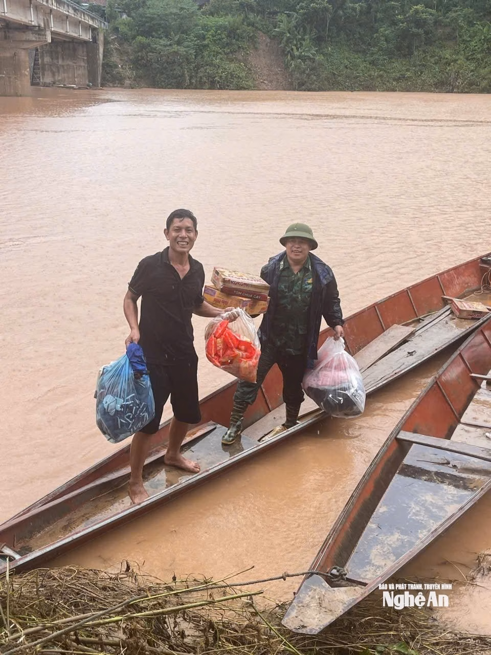 Người dân ‘tình làng nghĩa xóm’ giúp nhau vượt qua sau lũ Anh Lê Văn Quy (bên trái) hỗ trợ tiếp nhận hàng cứu trợ. Ảnh: Ngân Hạnh