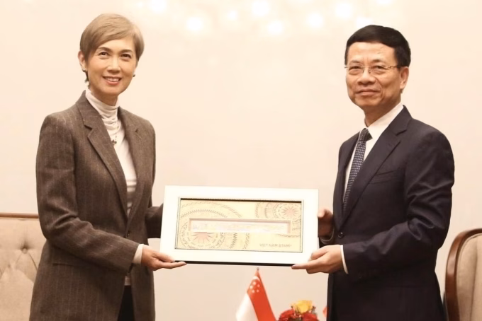 Bộ trưởng Nguyễn Mạnh H&ugrave;ng tặng qu&agrave; lưu niệm l&agrave; một bộ tem Việt Nam cho Bộ trưởng Ph&aacute;t triển Kỹ thuật số v&agrave; Th&ocirc;ng tin Singapore, s&aacute;ng 16/1. Ảnh: Do&atilde;n Mạnh