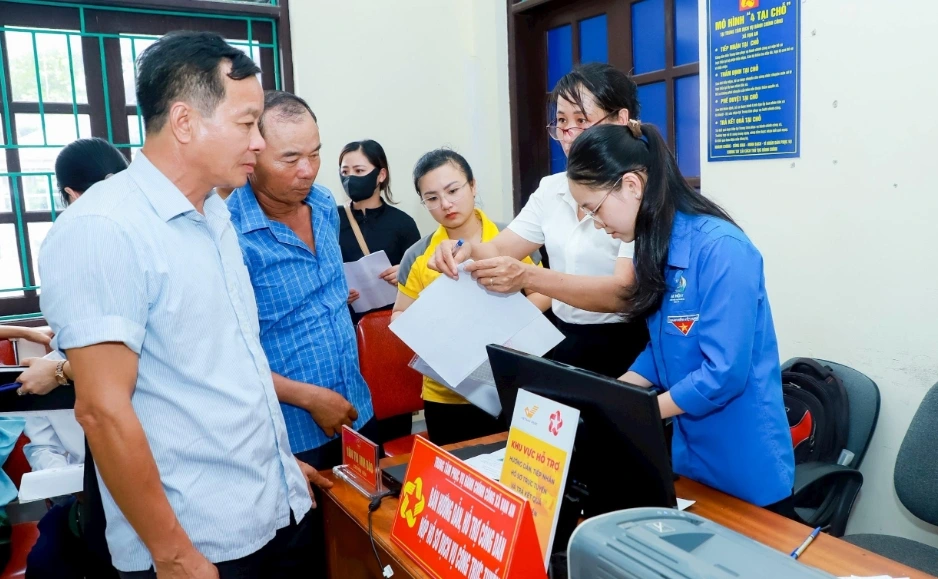 Nghệ An đổi mới cấp xã: Nâng cao năng lực phục vụ, đồng hành cùng công nghệ số Cán bộ xã Vạn An hướng dẫn người dân làm thủ tục.