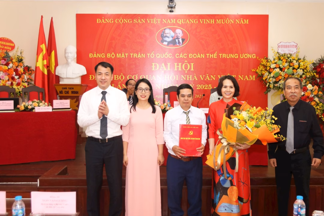 Phó Bí thư Đảng ủy MTTQ, các đoàn thể Trung ương Ngô Văn Cương trao Quyết định và tặng hoa chúc mừng Ban Chấp hành Đảng bộ Cơ quan Hội Nhà văn Việt Nam, nhiệm kỳ 2025-2030. Ảnh: Tiến Đạt.