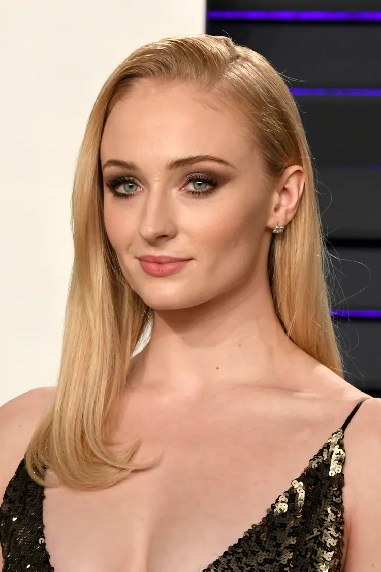 Bí quyết tạo kiểu tóc lật đẹp tại nhà từ các chuyên gia hàng đầu Sophie Turner with medium-length, strawberry blonde hair that's flipped inwards at the ends