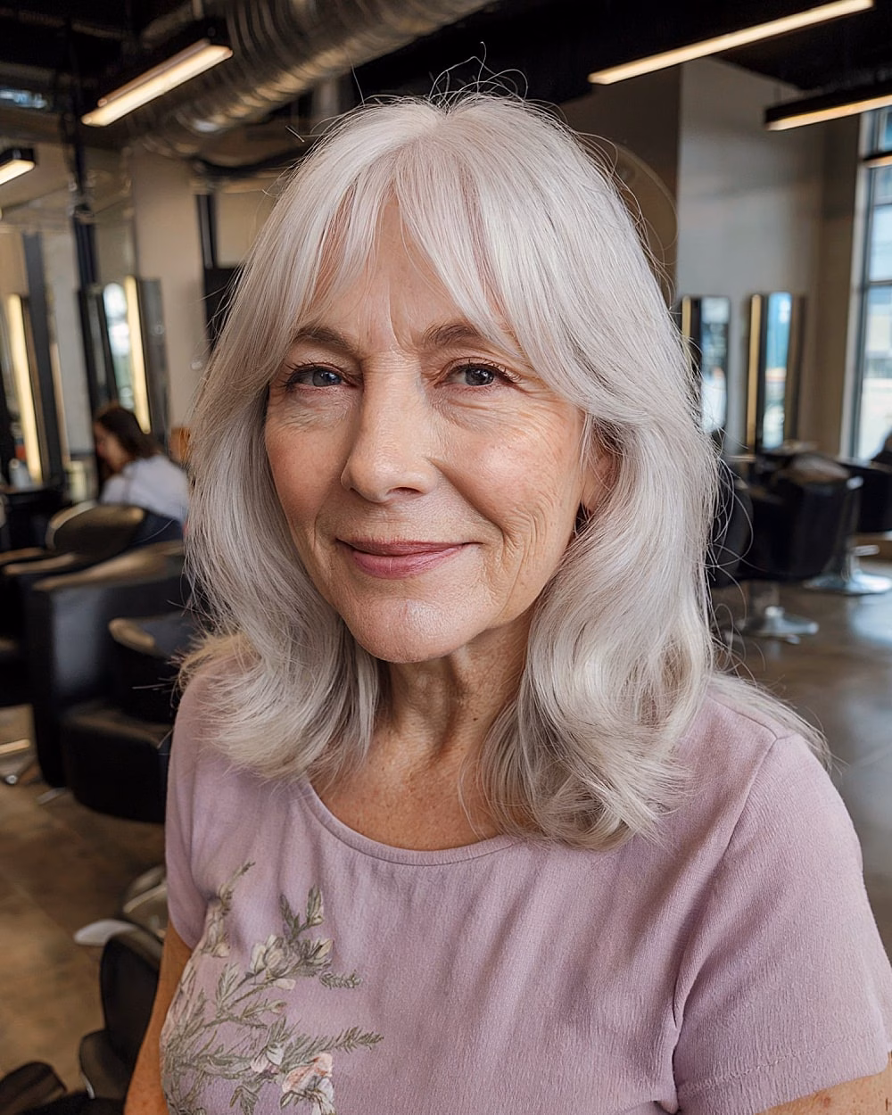 Light curtain bangs with soft waves framing the face for older women with gray hair