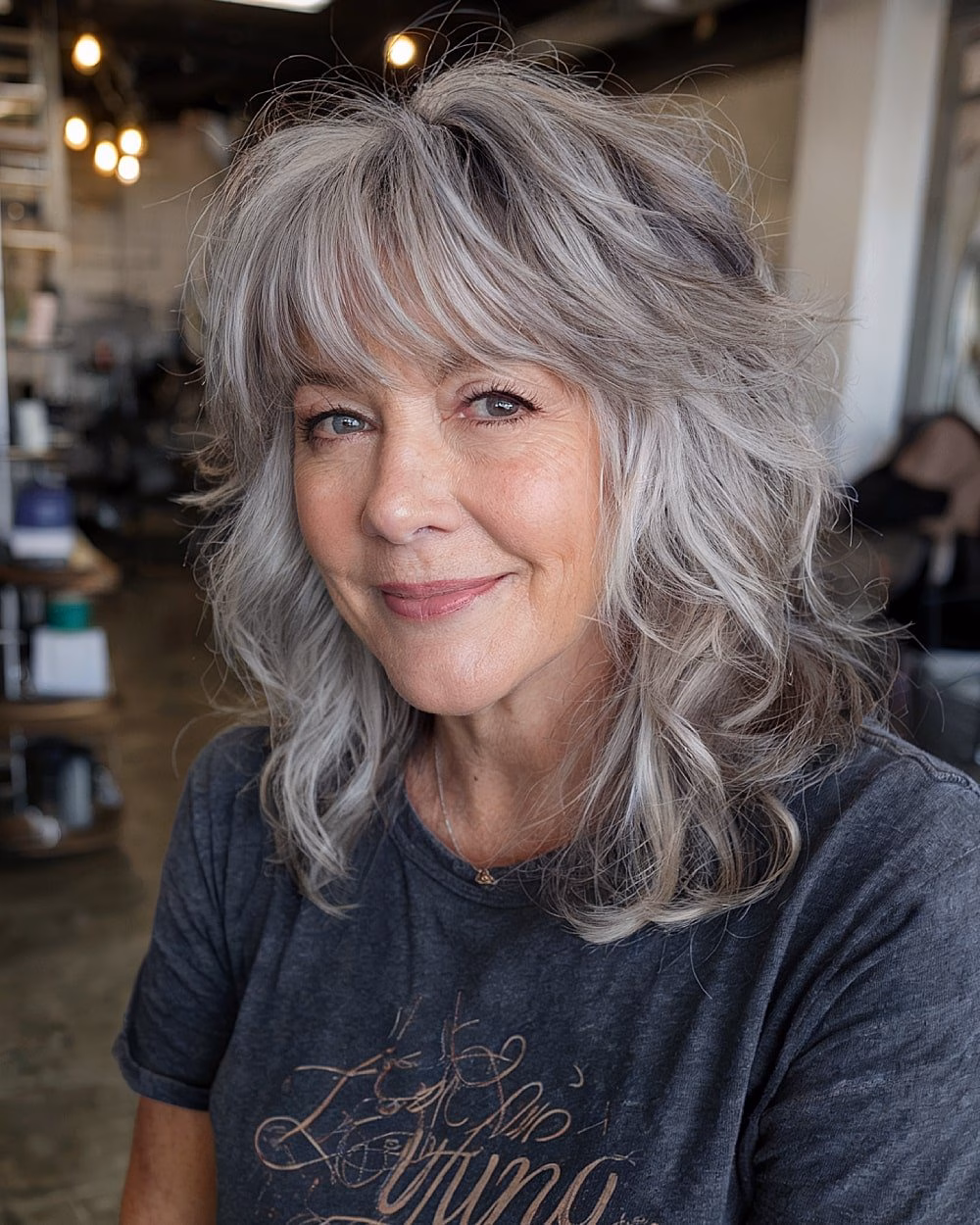Tóc tầng trung giúp chị em U60 trẻ trung, dễ chăm sóc Medium-length shaggy wolf cut with tousled layers and full fringe on silver hair