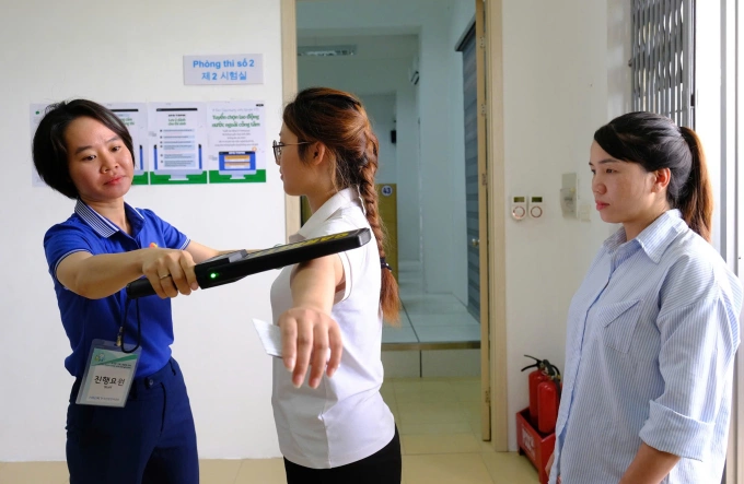 Cán bộ coi thi dùng máy dò kim loại Cán bộ coi thi dùng máy dò kim loại