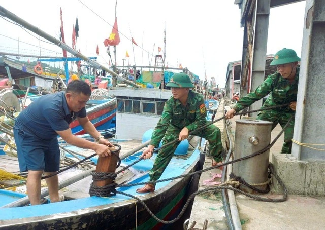 Lực lượng Bộ đội biên phòng tỉnh Nghệ An hỗ trợ ngư dân chằng néo tàu thuyền tại nơi tránh trú bão ngày 20.7