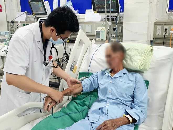 ThS.BS Hoàng Quốc Thái Bình, khoa Hồi sức tích cực, Viện Y học Nhiệt đới, Bệnh viện Bạch Mai, kiểm tra các vết xuất huyết trên da bệnh nhân. Ảnh: BVCC.