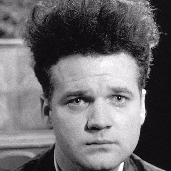 a person with distinctive hair style in a dark setting