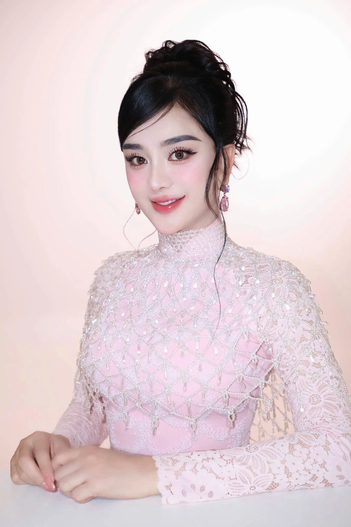 Áo dài giữa lòng di sản Giọng ca 48 tuổi búi tóc cao, trang điểm hài hòa và đeo bông tai tiệp màu, hoàn thiện hình ảnh nữ tính.