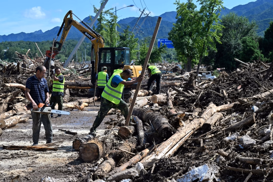 Bắc Kinh hứng mưa lớn, 30 người chết vì lũ Người dân địa phương cùng công nhân môi trường dùng cưa máy, máy xúc, dọn dẹp cây cối bị mưa lũ làm bật gốc và gãy đổ.