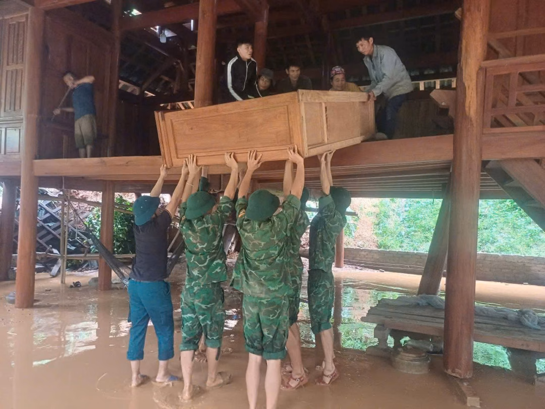 Hỗ trợ bà con di dời tài sản lên vị trí cao. Ảnh: BĐBP
