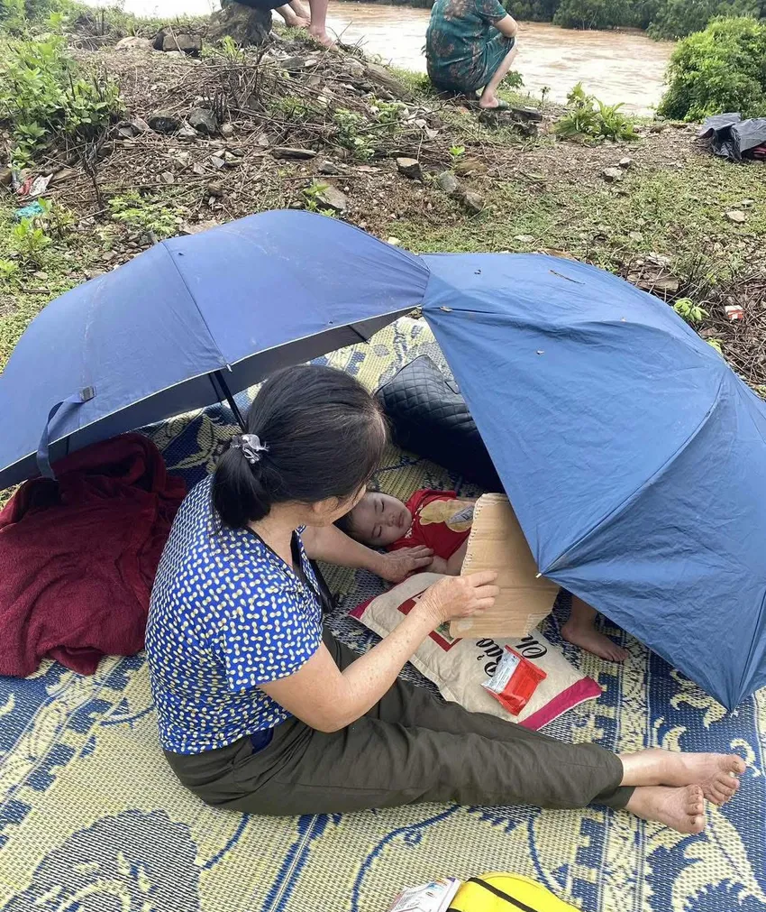 Mưa lũ lịch sử tại Nghệ An: Thiệt hại lớn về người và tài sản Một người dân ôm con lên núi lánh nạn.