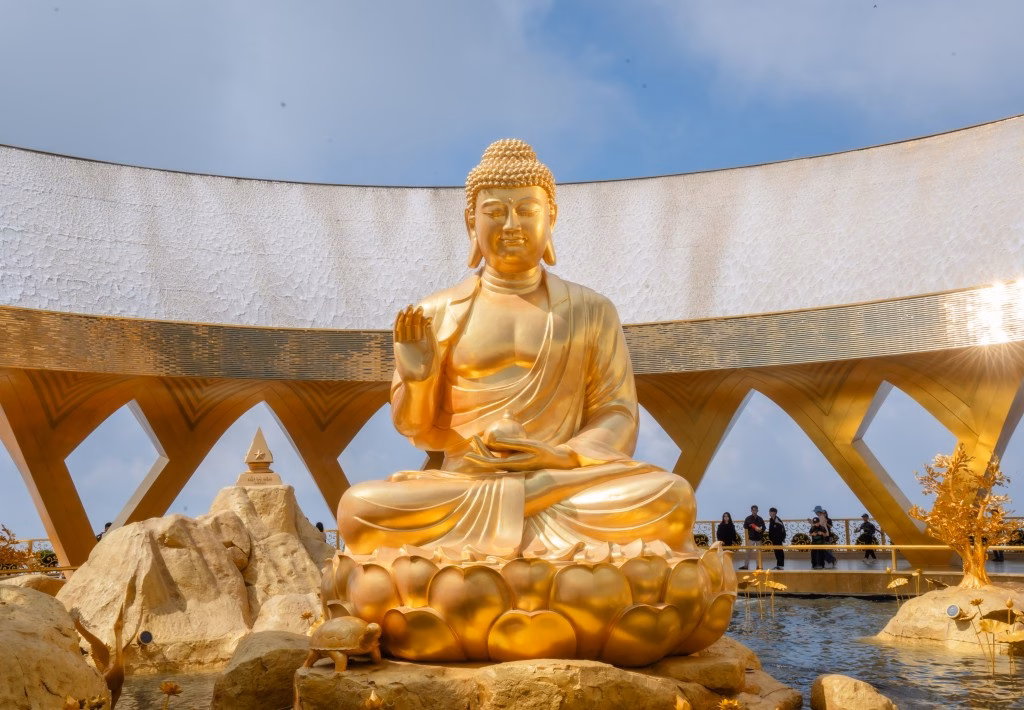 Tượng Phật Câu Na Hàm ngồi trên đài sen, tay nâng quả sung vàng tượng trưng cho sung túc Tượng Phật Câu Na Hàm ngồi trên đài sen, tay nâng quả sung vàng tượng trưng cho sung túc