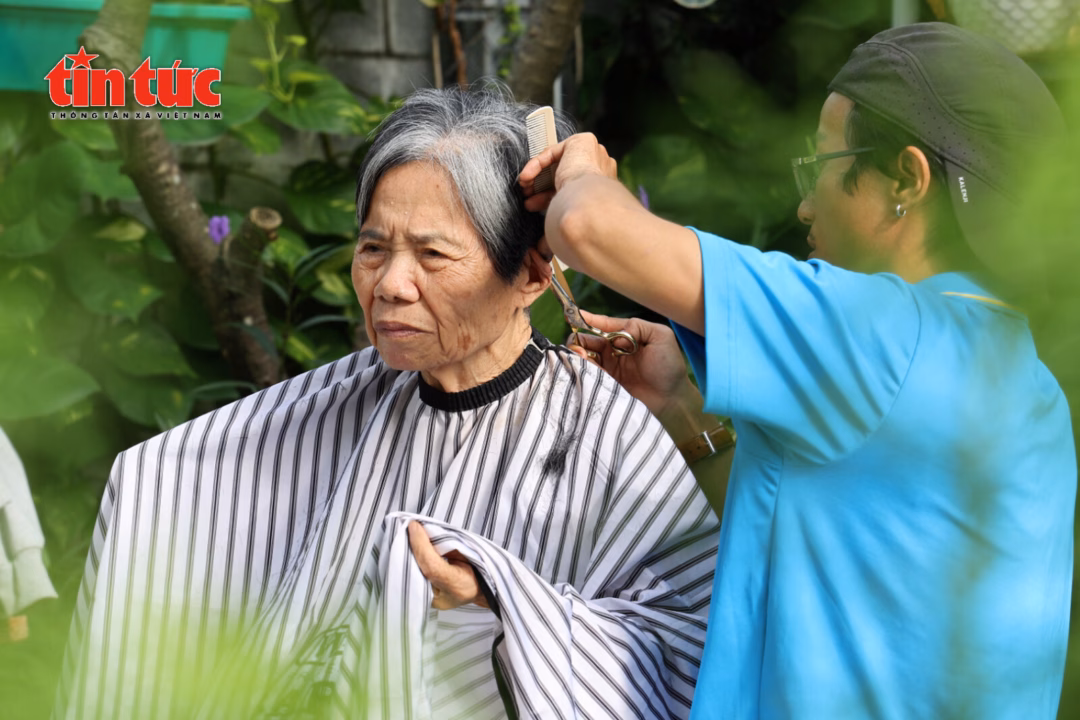 Các thành viên trong nhóm tỉ mỉ cắt tỉa, tạo kiểu tóc cho các cụ.