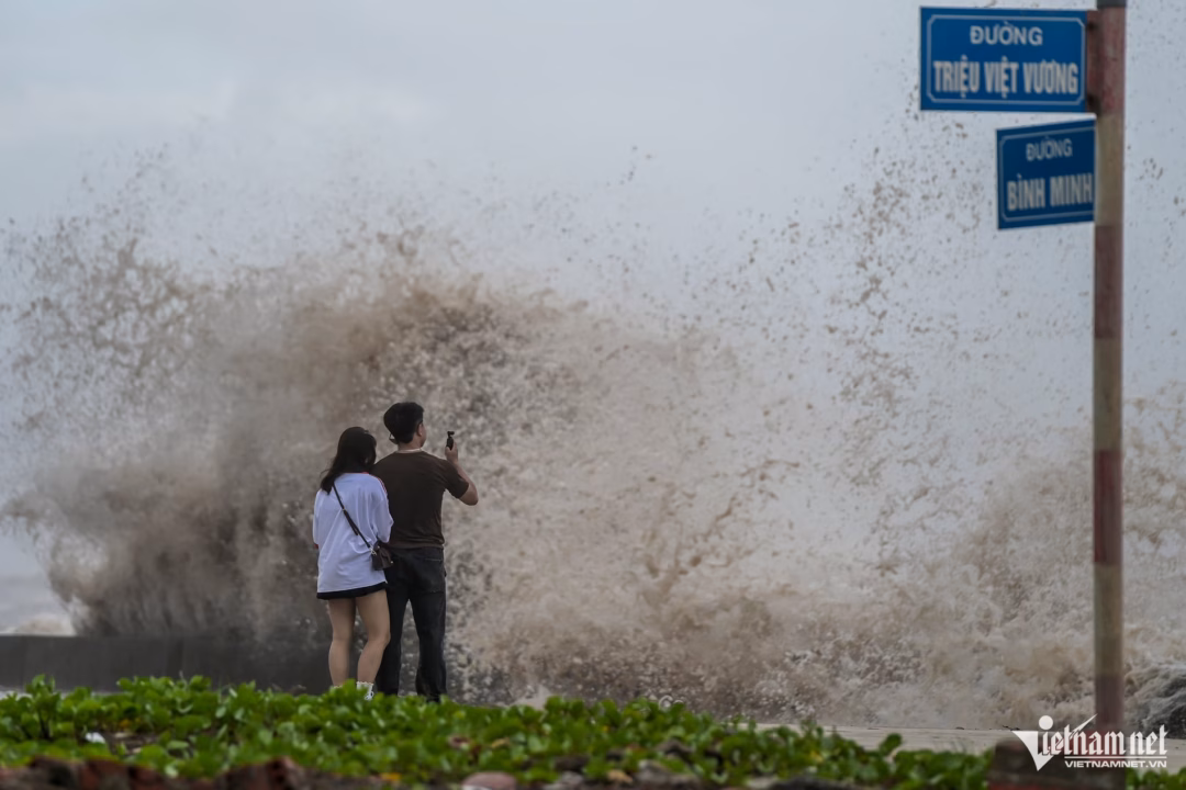 Bão đổ bộ, người dân ven biển vẫn bất chấp nguy hiểm ‘đu’ sóng lớn Cặp đôi chụp ảnh trước con sóng dữ vỗ vào bờ. Ảnh: Trọng Tùng