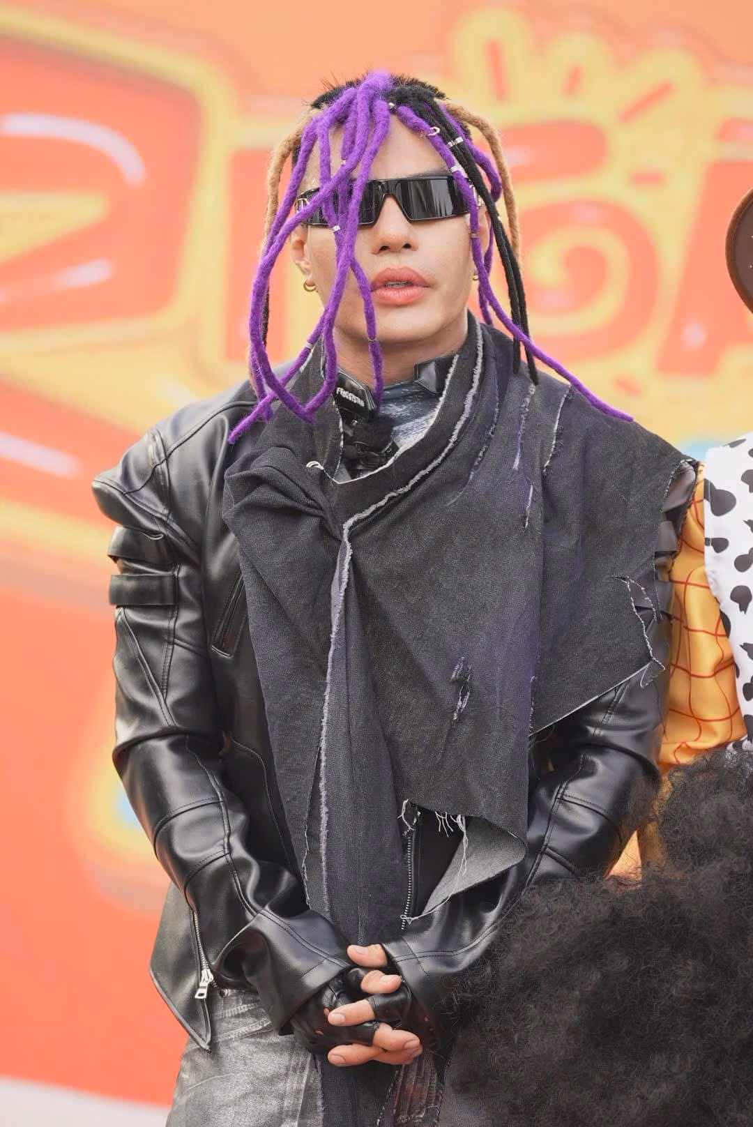 Lê Dương Bảo Lâm đội tóc giả kiểu dreadlocks tím nổi bật, diện kính râm đen cùng áo khoác da phong cách biker. Nhờ độ 'độc lạ', anh là thành viên gameshow nhận được nhiều sự chú ý nhất tuần qua với hơn 24 nghìn lượt đề cập theo thống kê của Socialite.