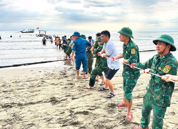 Lực lượng chức năng và người dân cứu hộ tàu thuyền bị sóng đánh chìm trên biển - Ảnh: H.A.
