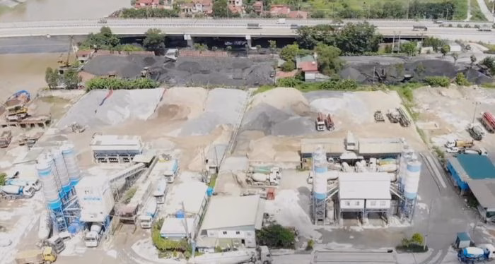 Khu vực tập kết vật liệu x&acirc;y dựng v&agrave; c&aacute;c trạm b&ecirc; t&ocirc;ng b&ecirc;n bờ s&ocirc;ng Cầu ngay dưới ch&acirc;n cầu Như Nguyệt