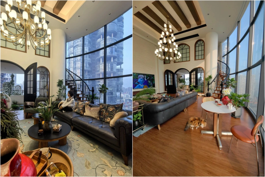 Không gian phòng khách thông tầng với vách kính cong view sông