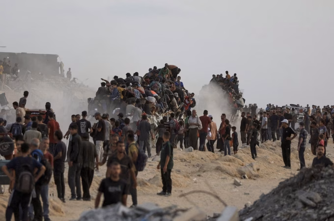 Người dân trèo lên các xe tải chở hàng viện trợ vào Gaza hôm 29/7. Ảnh: Reuters