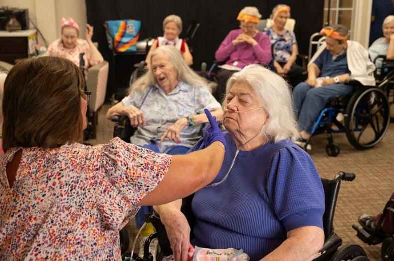 Deb takes her turn receiving makeup as a long line of Gorgeous Grandmas Day attendees wait patiently. Photo credit Julian Schnittker.