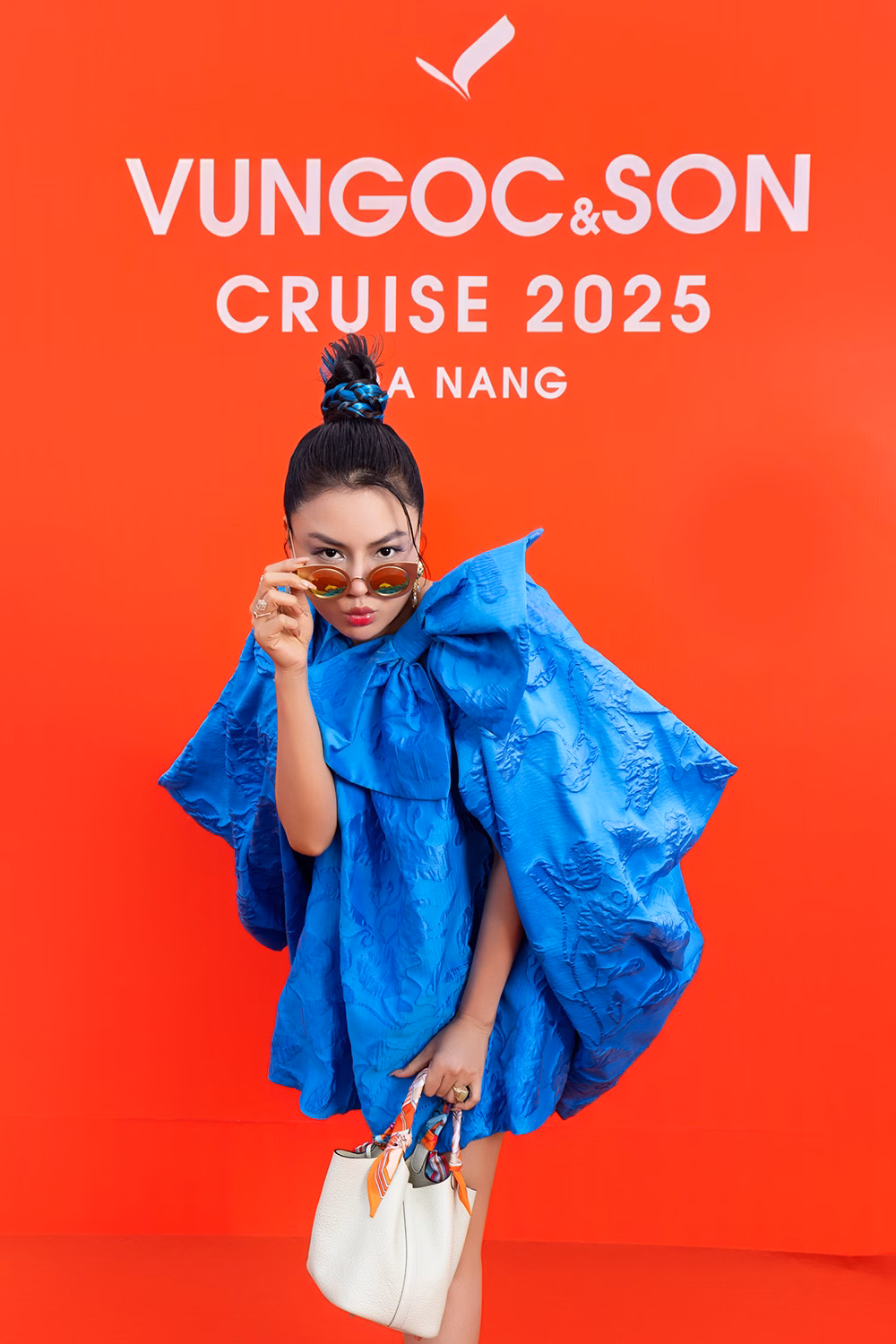 Show diễn VUNGOC&SON Cruise 2025: Thiên đường thời trang bên sông Hàn Siêu mẫu Vũ Thu Phương mặc váy có cape cách điệu lạ mắt, đính nơ to bản. Cô phối cùng chiếc túi xách Picotin của Hermès.